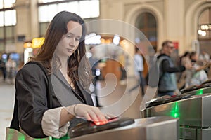 the passenger uses a transport card to pass through the turnstile, scanning train ticket to subway entrance gate