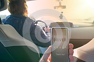 Passenger using smart phone app to rate a taxi or modern peer to peer ridesharing driver