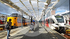 Two colorful commuter trains await passengers at a railroad station in Leeuwarden in the Netherlands