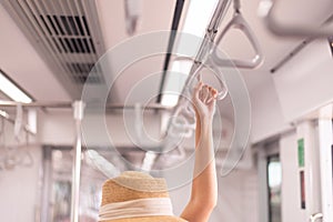 Passenger woman hand holding safety handle on the train