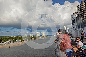 Passengers on  a cruise ship leaving Port Everglades, in Ft. Lauderdale, Florida look out over the ocean channel  with a luxury