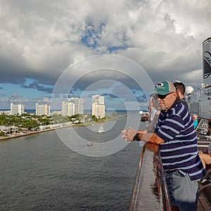 Passengers on  a cruise ship leaving Port Everglades, in Ft. Lauderdale, Florida look out over the ocean channel  with a luxury