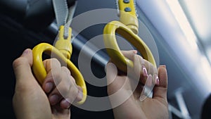 Passengers holding handrails in subway or bus, going to work in rush hour