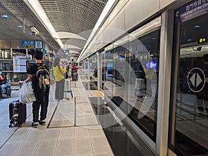 Passengers with luggage waiting for a Taoyuan International Airport MRT train on the Airport Terminal 1 platform in