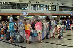 Passengers queue to check in at the airport