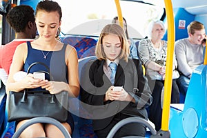 Passengers Sitting On Bus Sending Text Messages