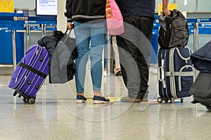 Passengers with suitcases are walking along the Airport waiting room