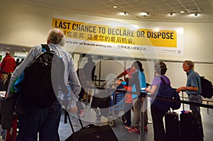 Passengers under Biosecurity sign in Auckland AIrport NZL