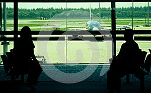 Passengers waiting at departure gate for boarding airplane