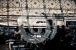 Passengers waiting at the gate in an airport in front of an airplane. Emirates Airbus A380 at Dubai International Airport. Dubai