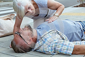 Passerby checks the vital functions of the person who fainted on the street