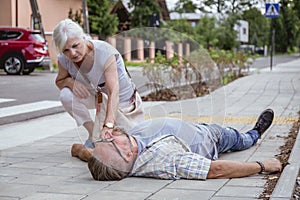 Passerby checks the vital functions of the person who fainted on the street