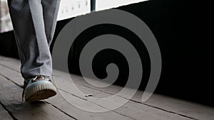 passerby is strolling alone, closeup view of legs and feet in casual sneakers