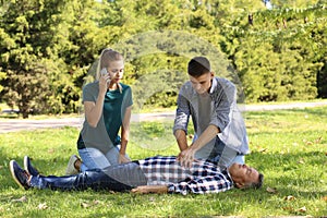 Passersby helping unconscious man outdoors photo