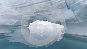 Passing through arctic iceberg arch in clear water