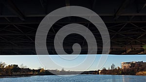 Passing on a boat underneath a bridge that spans a river