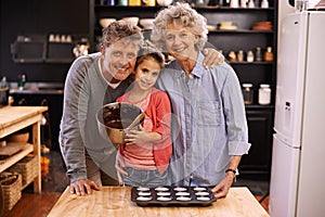 Passing down their secret family recipes. Portrait of a little girl and her grandparents making cupcakes in the kitchen.