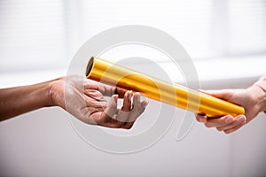 Passing Golden Relay Baton To Other Person