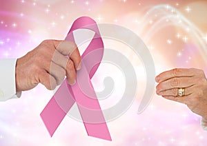 Passing hands with pink ribbon for breast cancer awareness