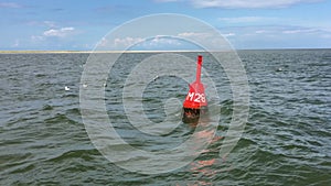 Passing a Red Buoy on the North Sea in the East Frisian Wadden Sea in front of Juist Island, Germany
