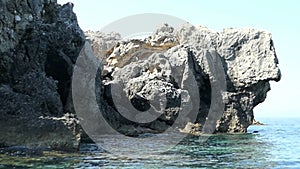 Passing by the turtle rock formation with a boat at Liapades Paradise beach area in Corfu Island Greece