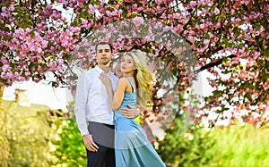 Passion concept. Man and woman in blooming garden. Couple spend time in spring tree garden. Loving people hug. Couple in