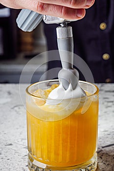 passion fruit cocktail on a gray stone bar counter