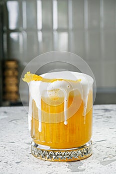 passion fruit cocktail on a gray stone bar counter