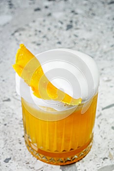 passion fruit cocktail on a gray stone bar counter