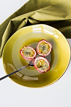 Passion fruit halves on green plate