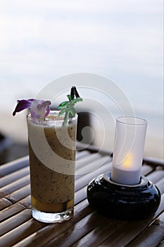Passion fruit juice is placed on a wooden table, twilight sea background