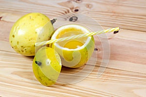 Passion fruits half and juice on the vintage wooden background