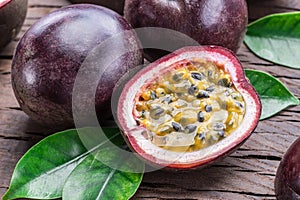 Passion fruits and its cross section with pulpy juice filled with seeds. Wooden background photo