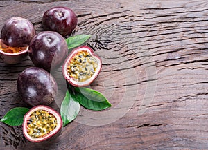 Passion fruits and its cross section with pulpy juice filled with seeds. Wooden background photo