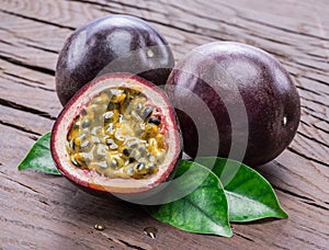 Passion fruits and its cross section with pulpy juice filled with seeds. Wooden background photo