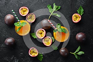 Passion fruits juice and fruit on a black background. Tropical Fruits. Top view.