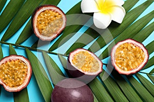 Passion fruits maracuyas, flower and palm leaf on blue background, flat lay