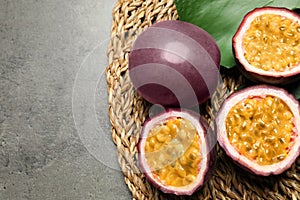 Passion fruits maracuyas and green leaf on grey table. Space for text