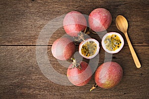 Passion fruits and slice with wooden spoon on wooden background.