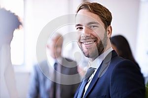 Passionate about business. Cropped view of a young businessman smiling while in a meeting.