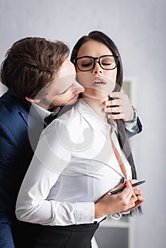 passionate businesswoman unbuttoning blouse while young