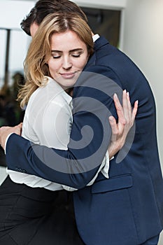 Passionate couple hugging and having a love affair in the office. Workplace flirt or romance. Business man and woman are