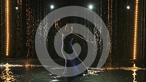 A passionate dancer of the incendiary dance of Argentine flamenco. A woman dances in the studio among rain drops and