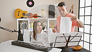 Passionate hispanic man and woman musicians engrossed in a melodious piano lesson together at a cozy music studio