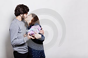 A passionate kiss of young couple. A happy woman kissing her boyfriend being happy and thankful to receive a present from him. Lo