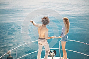 Passionate lovers dancing on bow of deck while sailing on yacht.