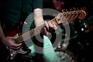 Passionate man strums guitar in a lively live music bar