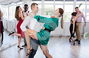 Passionate man and woman practicing tango in dancing studio