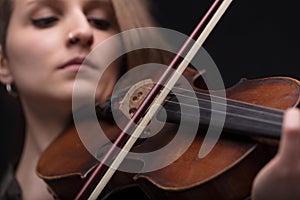 Passionate violin musician playing on black background