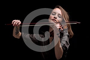 Passionate violin musician playing on black background